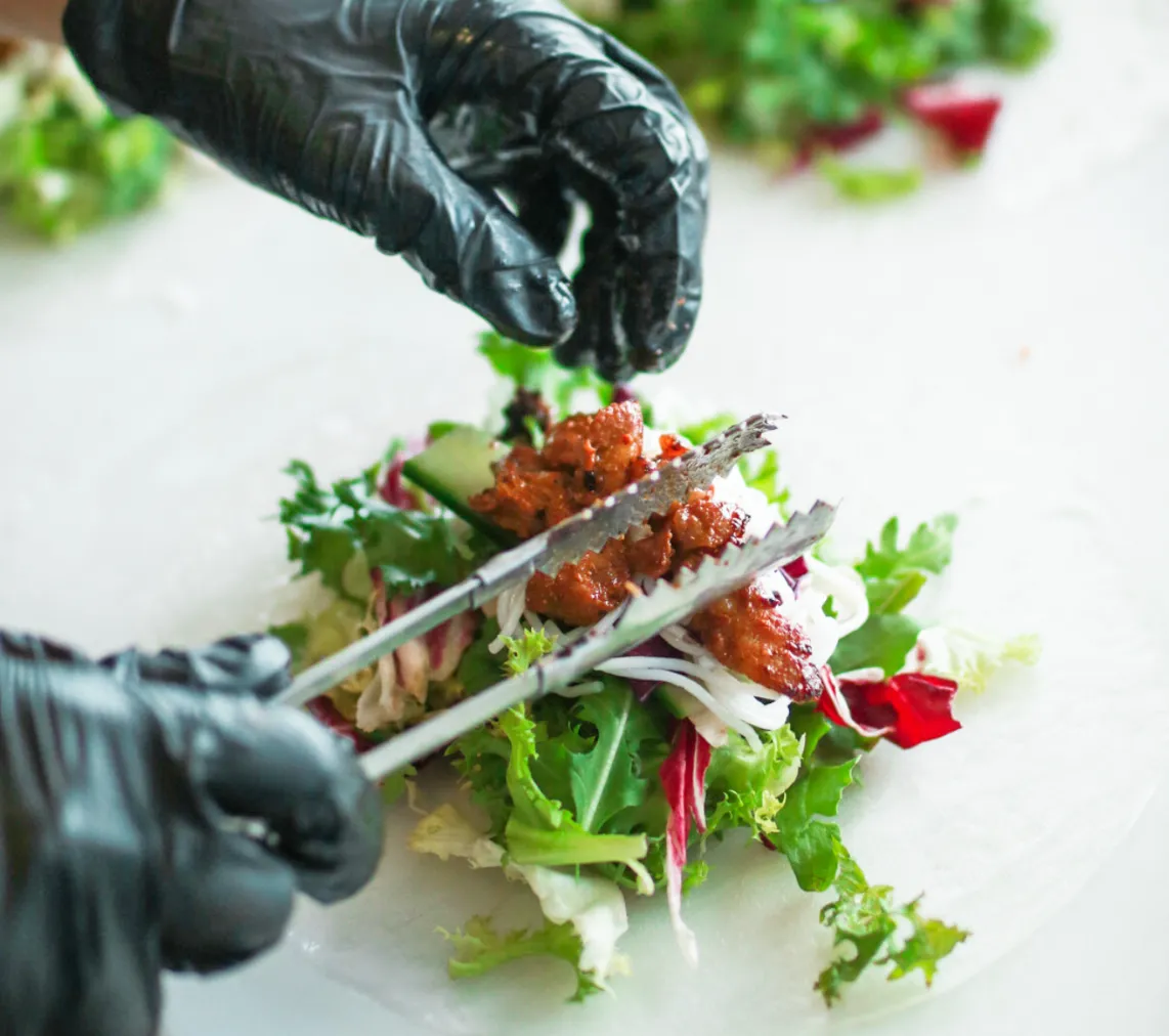 Kok anretter mad med tang i en foodtruck